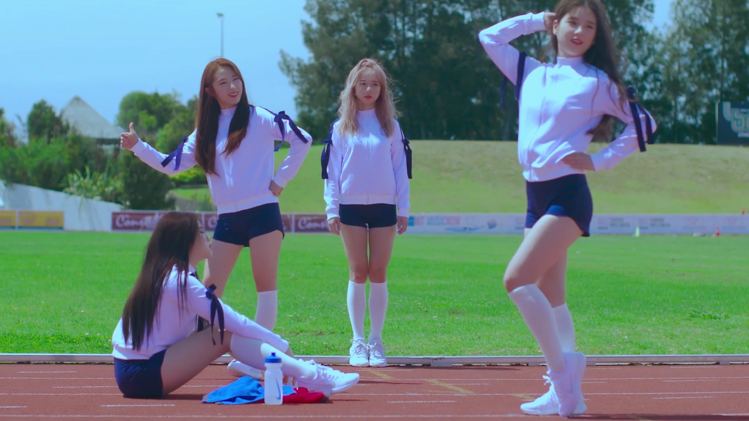 Loona One Third standing on the track. Heejin and Haseul are posing in a silly way.